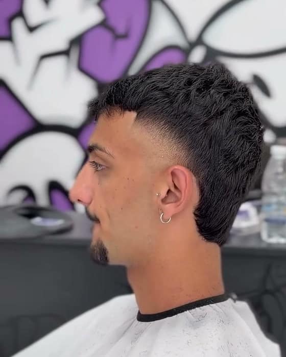 Κούρεμα με textured crop και mid fade, μπροστά στον μωβ τοίχο του RUDE BARBERSHOP