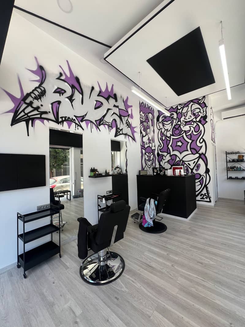 Το RUDE BARBERSHOP στο φως της μέρας: ο μωβ τοίχος, οι μαύρες καρέκλες και οι LED λωρίδες στο ταβάνι