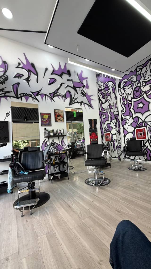 Οι τρεις καρέκλες του RUDE BARBERSHOP μπροστά στον μωβ τοίχο
