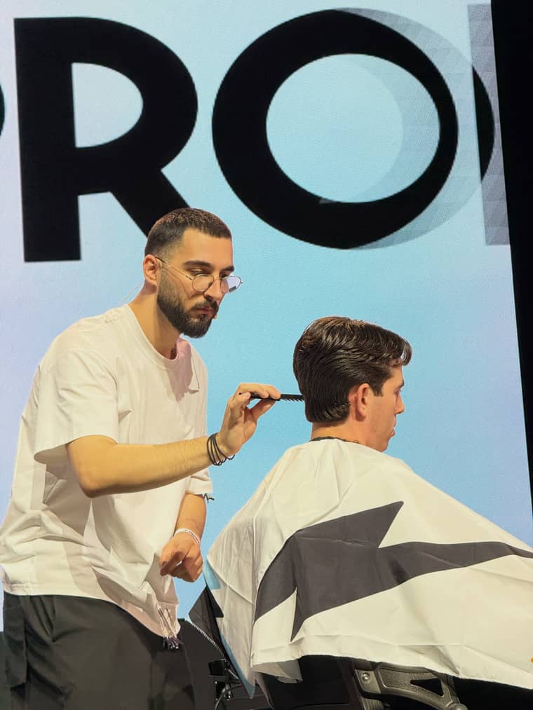 Ο Flavio κουρεύει ένα μοντέλο στη σκηνή του HairProf, με ψαλίδι και χτένα στα χέρια